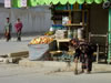 Little Girl sweeping in front of Shop 